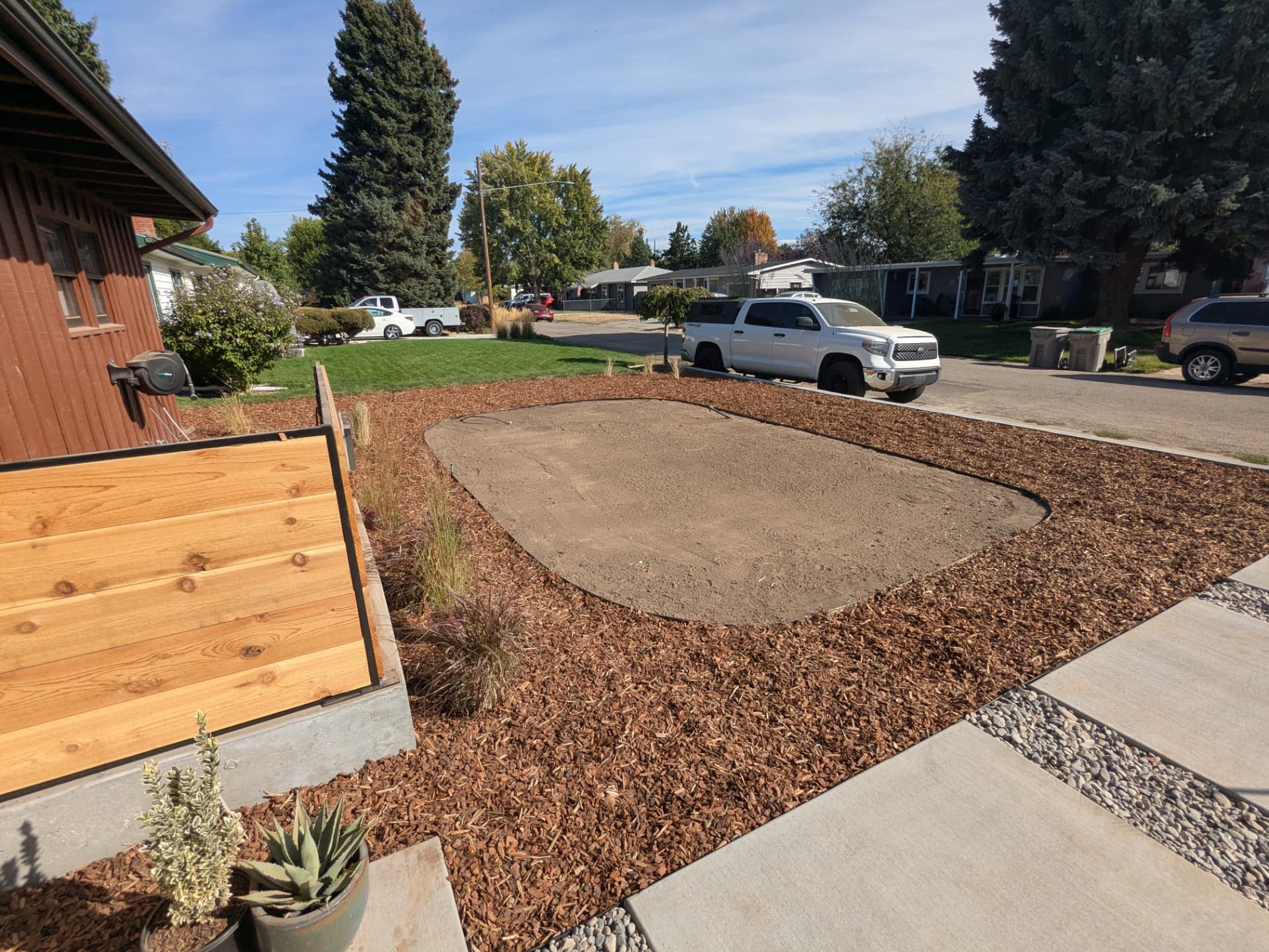 Fresh mulch spread in an edged bed beside a concrete walkway
