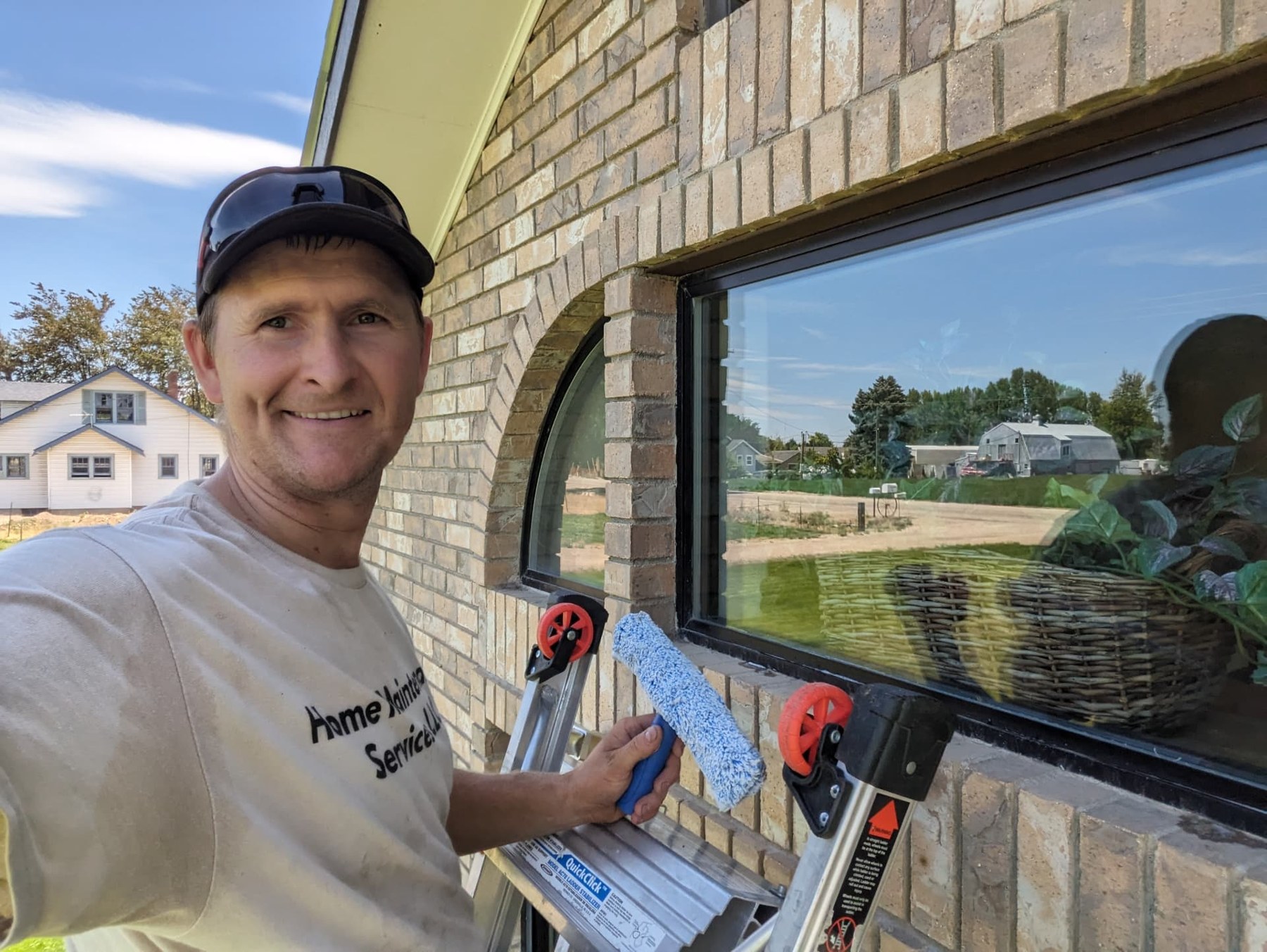 Crew member cleaning a residential window with professional tools