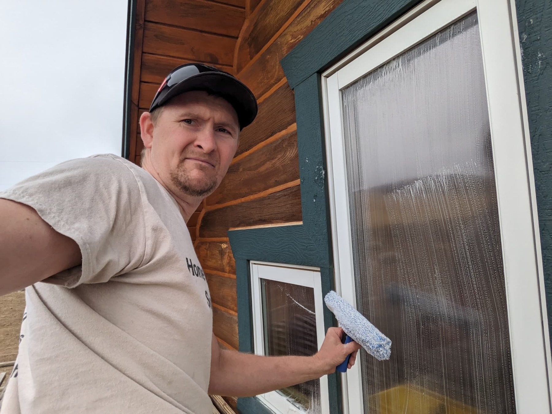 Crew member using a squeegee to clean exterior glass