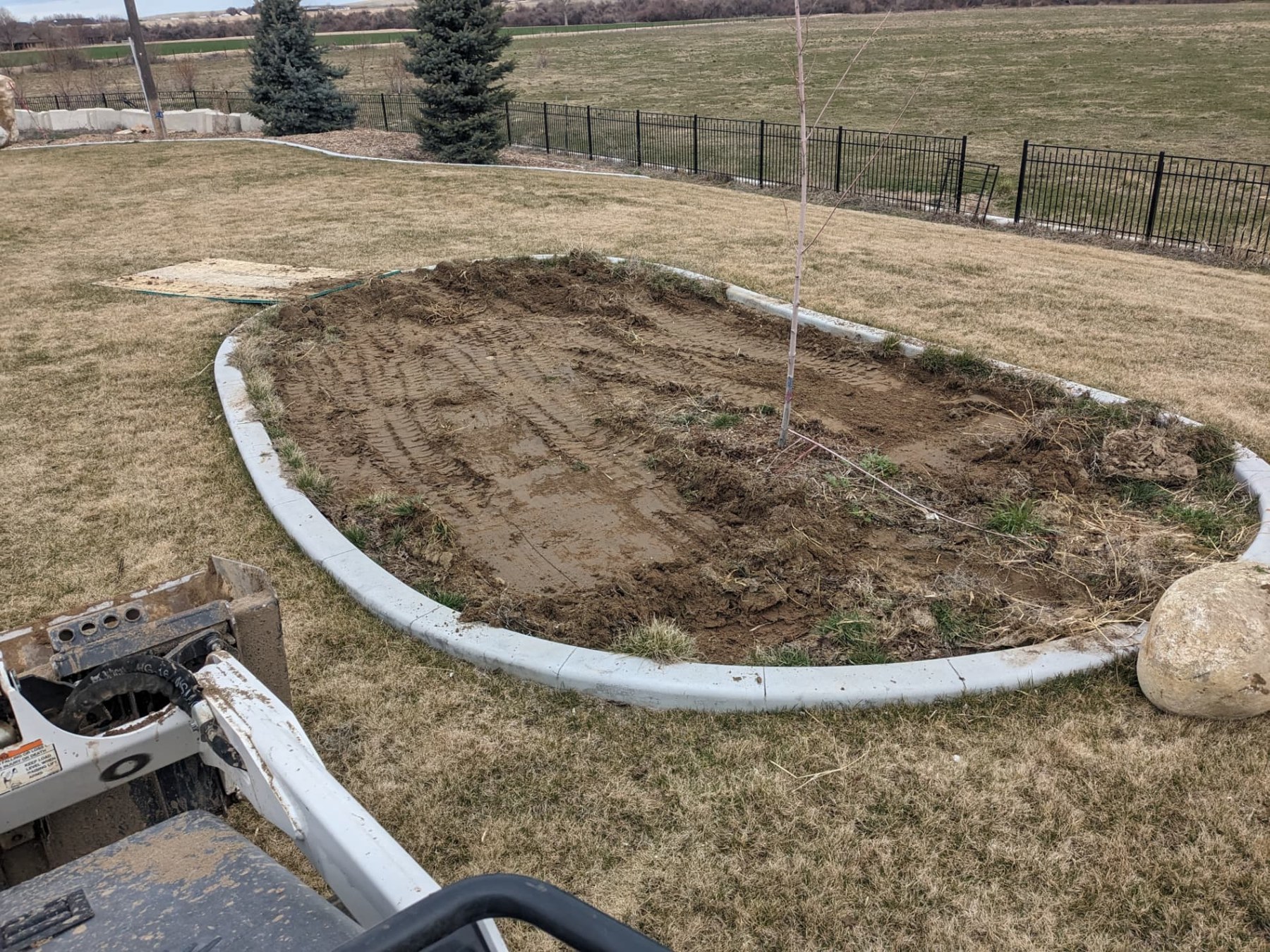 Excavated backyard patio area inside a curved border