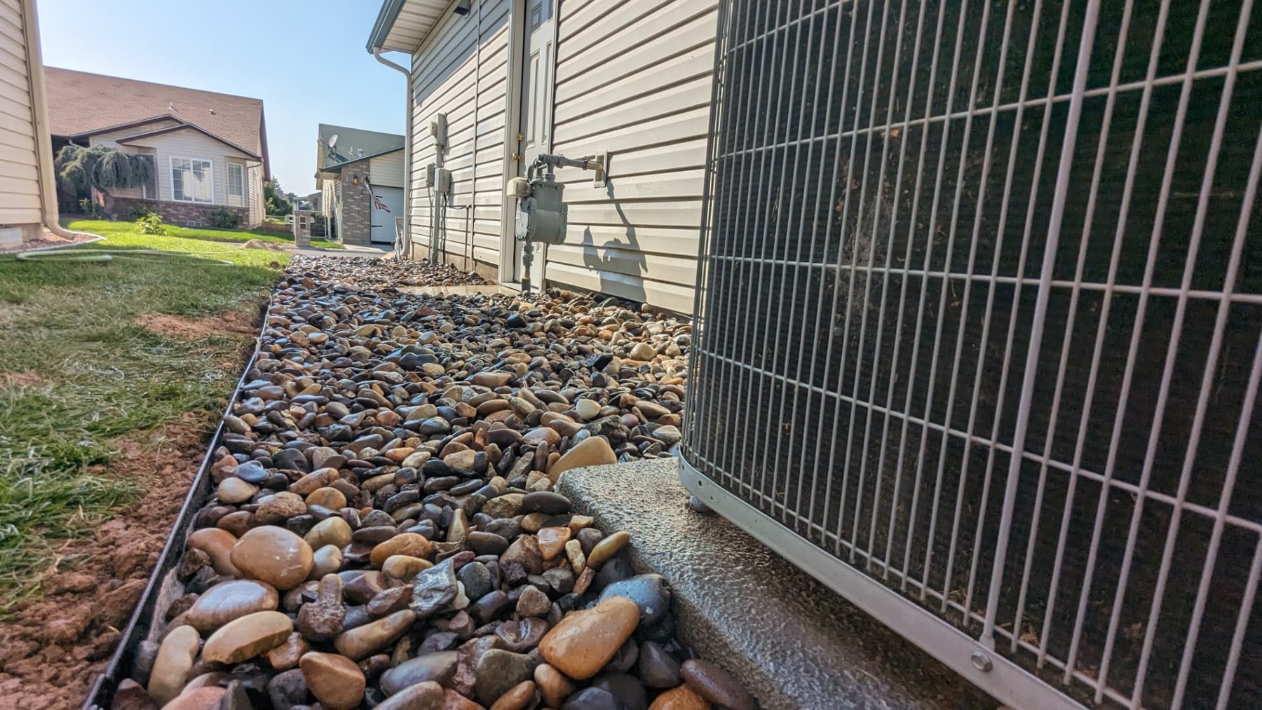 River rock landscape bed beside a home's outdoor air conditioning unit