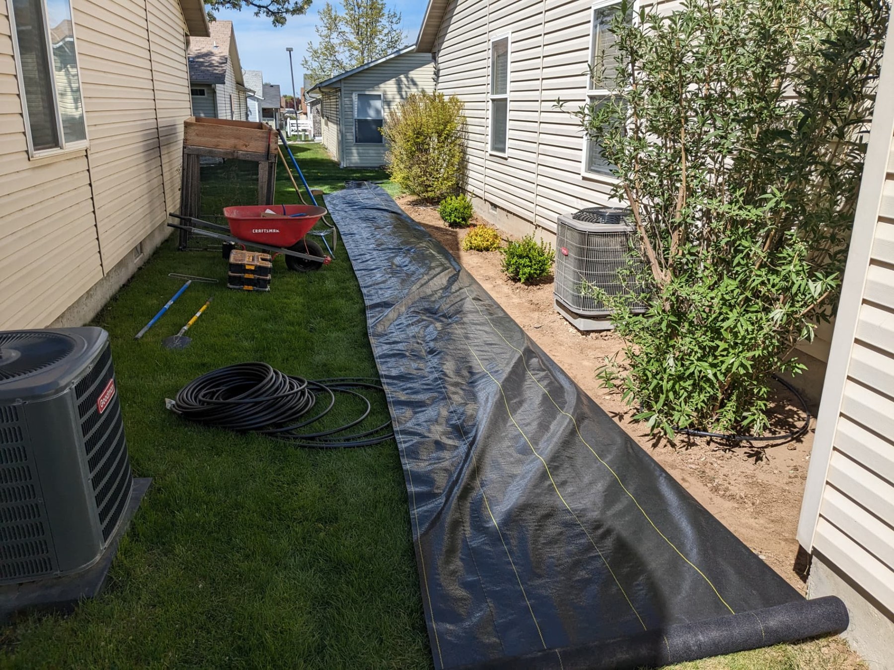 Landscape fabric laid beside a home during garden bed preparation