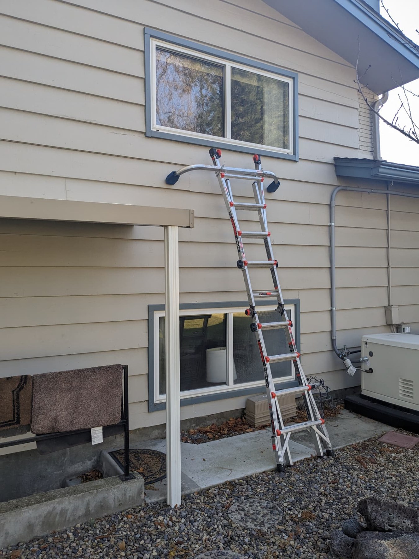 Ladder positioned beneath an upper window for exterior cleaning